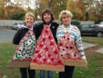 Here's an alt tag for the image: Three women in pizza slice costumes.