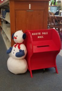 Here's an alt tag for the image: `Snowman next to North Pole mailbox`