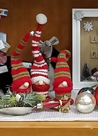Three Christmas gnomes with ornaments.