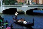 Gondola ride under a stone bridge.